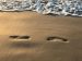 Huellas en la arena representando la de carbono